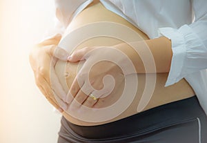 Portrait of a pregnant woman touching her belly
