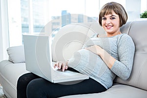 Portrait of pregnant woman using laptop