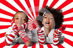 Portrait of a preschool cute african-american children laying down. Studio shot. Two kids on geometric background