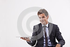 Portrait, presentation and man holding a tablet, communication or digital app on white studio background. Face, person