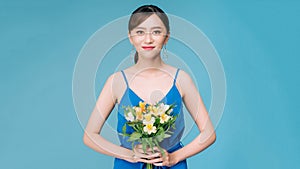 Portrait of pretty asian woman holding yellow flowers. Charming girl posing with bouquet