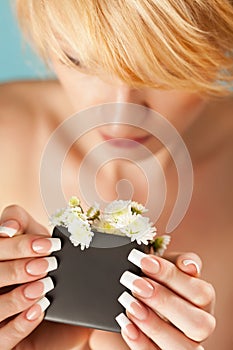 Portrait of a pretty blond young woman smelling flowers