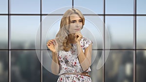 Portrait of a pretty blonde woman using an invisible virtual screen indoors.