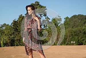 Portrait of a pretty brunette posing against tropical woods