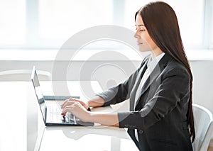 Portrait of pretty business woman with laptop in the offic