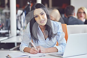 Portrait of pretty businesswoman working in the office and looks busy while making a note on the notebook