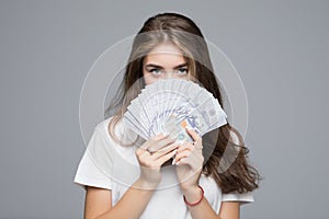 Portrait of pretty charming positive glad funny woman covering closing half face with fan from dollars looking out with eyes at ca