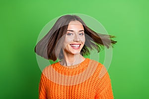 Portrait of pretty cheerful girl toothy smile flying hair empty space isolated on green color background