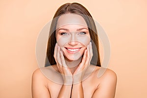 Portrait of pretty cheerful girl touching soft shine skin domestic procedure isolated over beige pastel color background