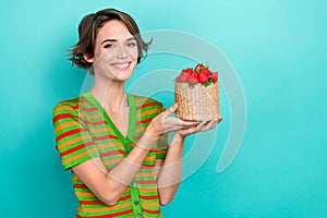 Portrait of pretty cheerful person hands hold fresh strawberry basket empty space isolated on teal color background