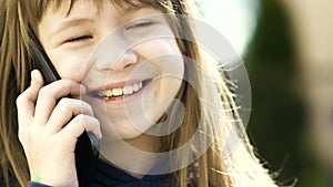 Portrait of pretty child girl with long hair talking on cell phone. Little female kid communicating using smartphone. Children com