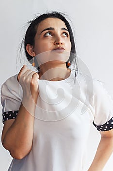 Portrait of a pretty confident woman, holding hand near the face, looking upwards with thoughtful face expression. Attractive