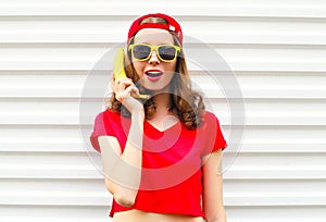 Portrait pretty cool woman with banana having fun over white