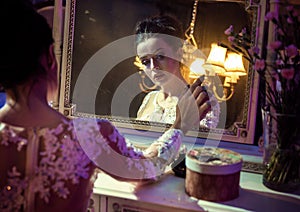 Portrait of a pretty countess touching an antique mirror photo