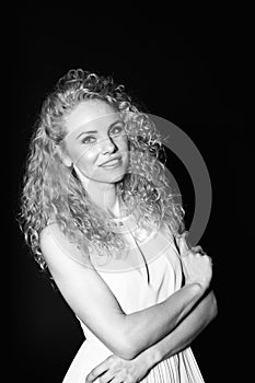 Portrait of a pretty curly blonde woman, wearing light dress