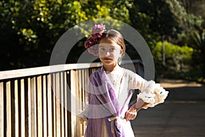 Portrait of a pretty girl dancing flamenco in a dress with frills and fringes typical of gypsies, walking on a wooden bridge in a