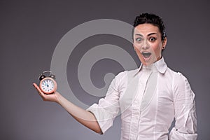 Portrait of pretty girl holding an alarm clock in