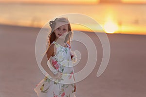 Portrait of pretty girl smiling at sunset on the sea