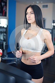 Portrait of pretty girl training on special sport equipment in g