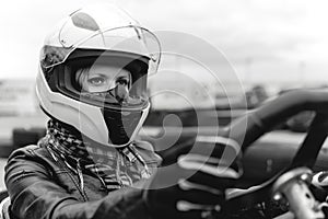 Portrait of a pretty girl wearing a white helmet close up, detail of Go-kart. karting track racing, copy space. serious look,