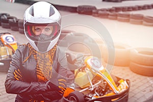 Portrait of a pretty girl wearing a white helmet close up, detail of Go-kart. karting track racing, copy space. serious look,