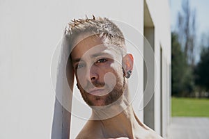 Portrait of a pretty guy dressed in boxers on a concrete wall