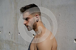 Portrait of a pretty guy dressed in boxers on a concrete wall