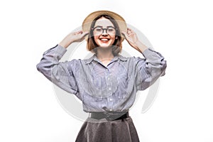 Portrait of pretty joyful girl in straw hat ready for journey posing in studio over white background.