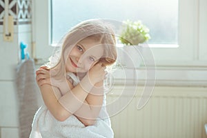 Portrait of pretty little child girl with white towel after show