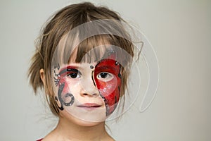 Portrait of pretty little girl with butterfly painting on her fa