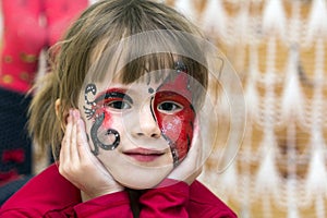 Portrait of pretty little girl with butterfly painting on her fa