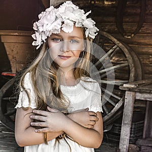 Portrait of pretty little girl. Fashion portrait of beautiful little girl with wreath and white dress. Spring fashion and