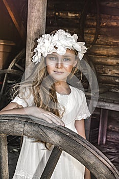 Portrait of pretty little girl. Fashion portrait of beautiful little girl with wreath and white dress. Spring fashion and