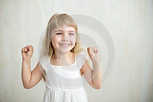 Portrait of pretty little girl in white dress.