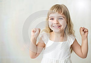 Portrait of pretty little girl in white dress.