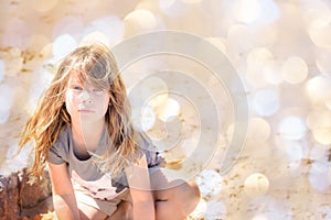 Portrait of a pretty little girl with windy hair on the beach in summer