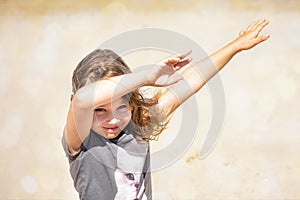 Portrait of a pretty little girl with windy hair on the beach in summer