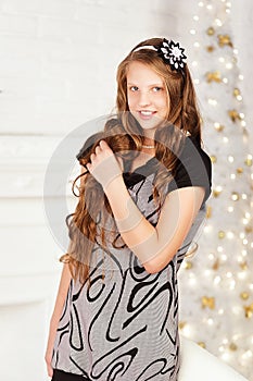 Portrait of pretty long-haired smiling teen girl in dress in int