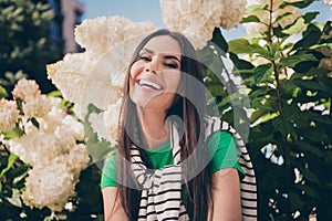 Portrait of pretty lovely girlish nice young lady standing in blooming summertime flowers bush enjoying nature