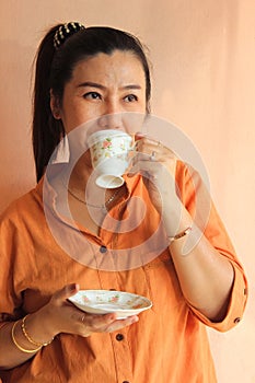 Portrait of pretty middle aged woman drinking coffee at home.