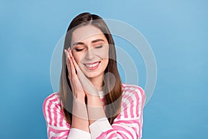 Portrait of pretty nice lady closed eyes arms under cheekbone isolated on blue color background