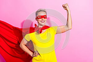Portrait of pretty positive girl toothy smile arms showing flexing biceps wear red cape mask isolated on pink color