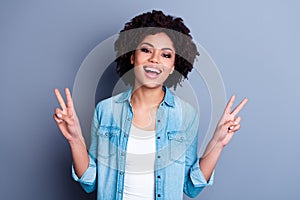 Portrait of pretty positive lady toothy smile arms fingers demonstrate v-sign isolated on grey color background