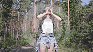 Portrait pretty scared young woman gets lost in the forest, she calling for the help. The girl despair, she is alone in