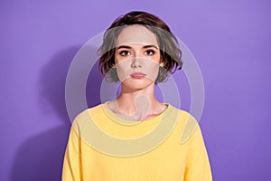 Portrait of pretty serious girl look in camera wear bright sweatshirt isolated over purple color background