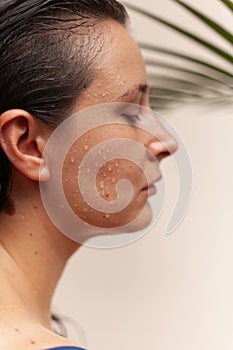 Profile of beautiful woman with water drops on her face