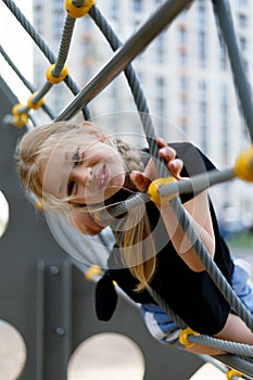 Portrait of a pretty smiling little preschooler girl at the playground