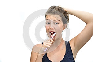 Portrait of pretty smiling teen brushing her teeth isolated on white background