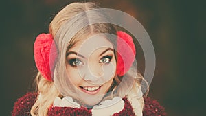 Portrait of pretty smiling woman in red earmuffs.