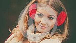Portrait of pretty smiling woman in red earmuffs.